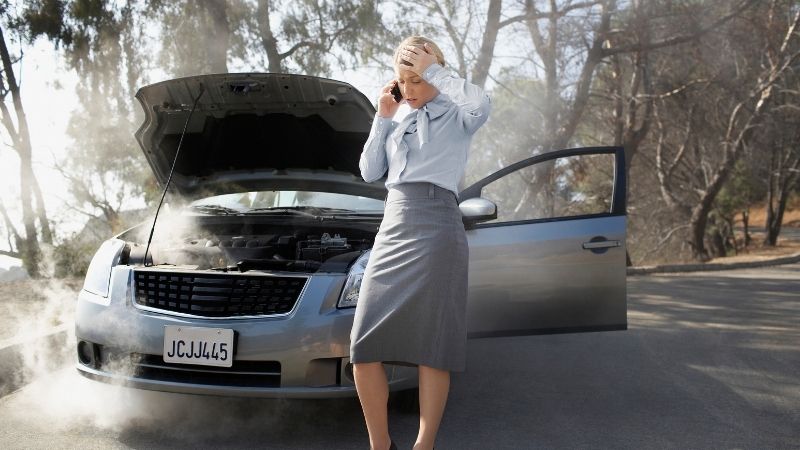 Woman broken down on side of the road, calling tow truck